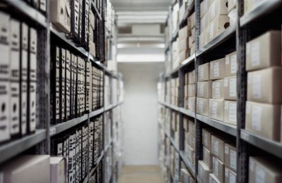 Rows of shelving stacked with labelled storage boxes in a stockroom